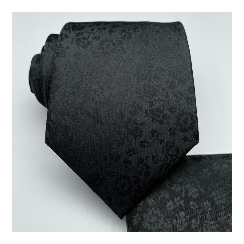 May include: A black silk tie with a subtle floral pattern.