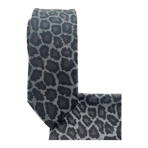 May include: A gray and black patterned tie with a leopard print design.