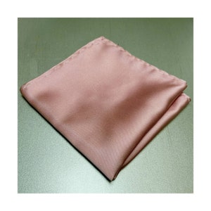 May include: A folded dusty rose colored pocket square. The fabric is smooth and silky.
