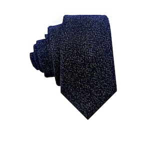 May include: A dark blue tie with a subtle sparkle finish. The tie is made of a textured fabric and has a classic design.