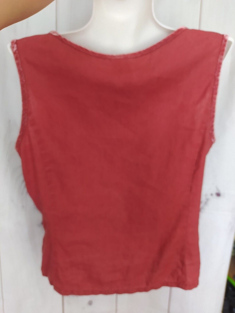 May include: A sleeveless, red tank top with a scoop neck.