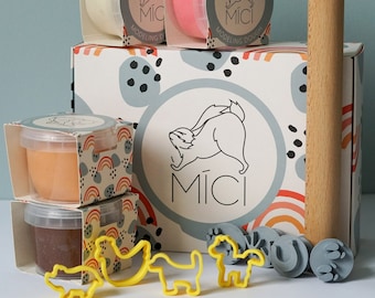 Puede incluir: Un conjunto de masa para modelar de colores en recipientes con un rodillo, cortadores de galletas y sellos. La masa está etiquetada como "Veidosanas Mikla" y "Mici Modeling Dough".