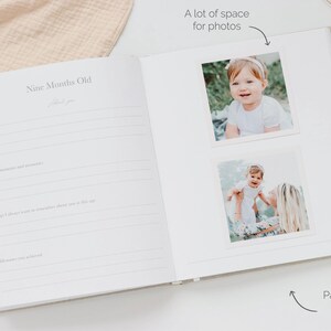 May include: An open baby memory book with a page titled Nine Months Old featuring lined sections for notes and milestones. The right page displays two square photographs of a child, with text annotations indicating space for photos and a page spread.