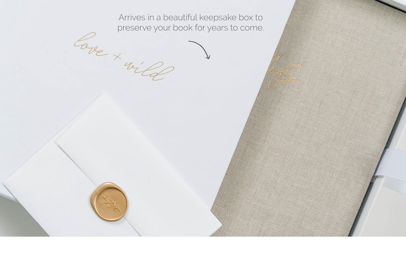 May include: A white box containing a beige linen-covered book and a white envelope sealed with a gold wax stamp featuring a botanical design. The box lid displays the text "love + wild" and "Arrives in a beautiful keepsake box to preserve your book for years to come" with an arrow.