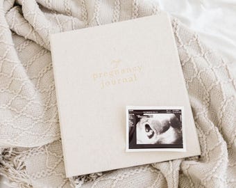 May include: A beige pregnancy journal with the text "My Pregnancy Journal" on the cover. A black and white ultrasound image is placed on the front of the journal.