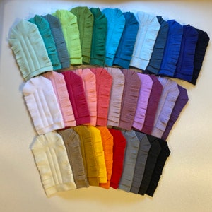 May include: A collection of 20 colorful fabric headbands with a fringed edge. The headbands are arranged in a fan shape, with the lightest colors at the top and the darkest colors at the bottom.