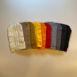 May include: A set of ten felt fabric strips with fringed edges in various colors, including white, brown, yellow, orange, red, gray, and black.