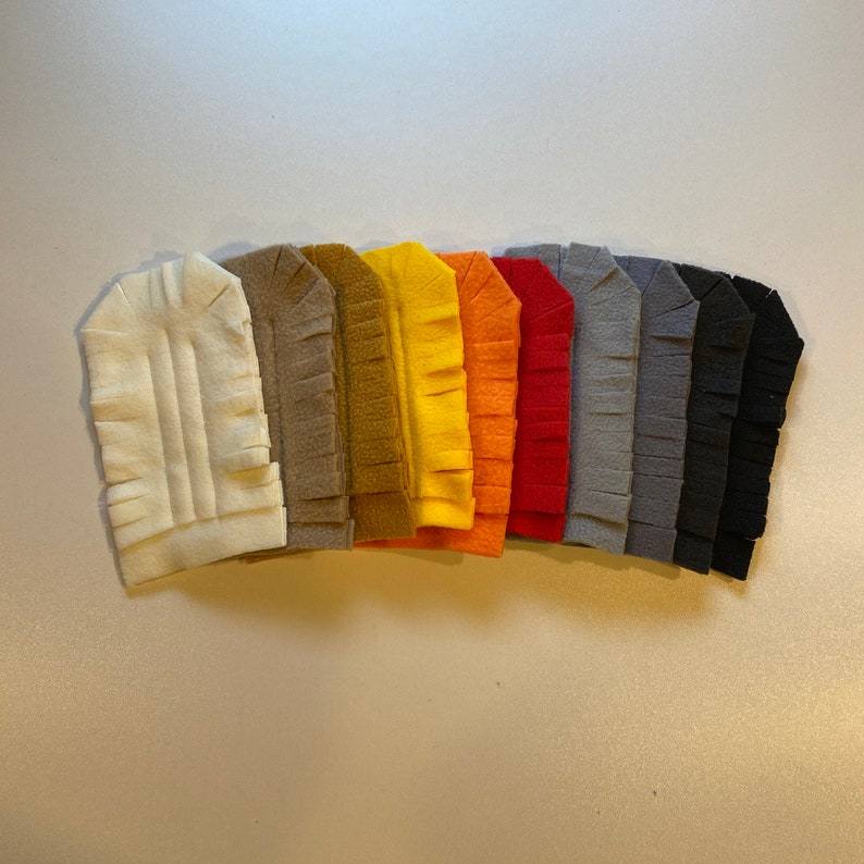 May include: A set of ten felt fabric strips with fringed edges in various colors, including white, brown, yellow, orange, red, gray, and black.
