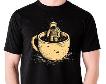 Camiseta negra unisex inspirada en AI con un astronauta sentado en una taza de café con estrellas y un fresco regalo de cumpleaños de Navidad. Arte con IA Diseño con IA