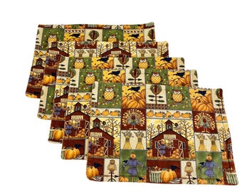 May include: Set of five rectangular placemats with a patchwork design featuring autumn harvest scenes. The placemats display images of pumpkins, owls, scarecrows, and barns in shades of orange, green, brown, and yellow.