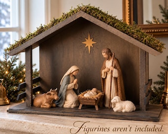 Könnte beinhalten: Ein dunkelbrauner Holzstall mit einem moosbedeckten Dach und einem goldenen Stern an der Rückwand. Die Struktur hat offene Seiten und einen flachen Boden. Der Text lautet: Figurines aren't included. STABLE ONLY.