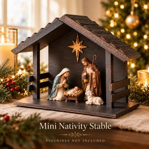 May include: A dark brown wooden nativity stable featuring a gabled roof and a cutout star mounted on the back wall. The structure has open sides with horizontal slats and a flat base. Text on the image reads Mini Nativity Stable and Figurines Not Included.