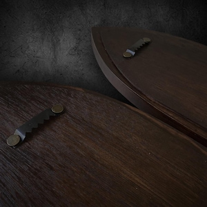 Close-up of dark walnut sconce backs showing sawtooth hanger mounting hardware