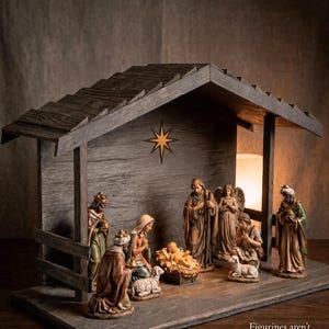 May include: A wooden nativity stable with a gabled roof and a star emblem on the back wall. The structure features a base and side supports. Text on the lower right reads: Figurines aren't included — stable only. The wood has a dark, weathered finish.