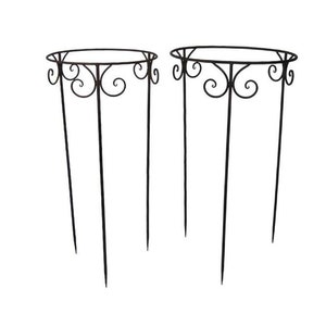May include: Two black metal plant stands with a decorative scroll design. Each stand has four legs and a circular top.