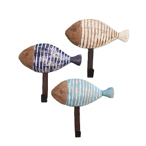 Peut inclure: Ensemble de trois crochets en bois en forme de poisson avec des rayures bleues, blanches et brunes. Les crochets sont en métal et ont un aspect rustique.