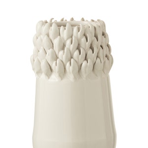 Może przedstawiać: Biały ceramiczny wazon z fakturowanym wzorem liści wokół górnej części.