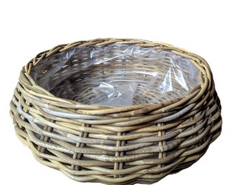 Jardinera grande hecha de cesta plana y redonda.