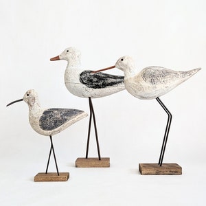 Houten sculptuur van een meeuw op een sokkel, verkrijgbaar in drie maten en varianten.