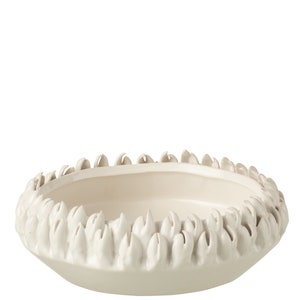 Op de afbeelding: Een witte keramische kom met een decoratieve, getextureerde rand. De rand is gevormd als een reeks kleine, puntige bladeren.