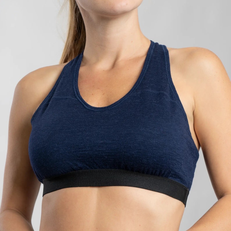 K&ouml;nnte beinhalten: Ein marineblauer Sport-BH mit Racerback-Design und einem schwarzen elastischen Band am unteren Rand.
