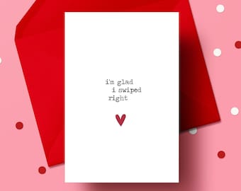 May include: A white card with a red envelope on a pink background. The card says "I'm glad I swiped right" with a small red heart.