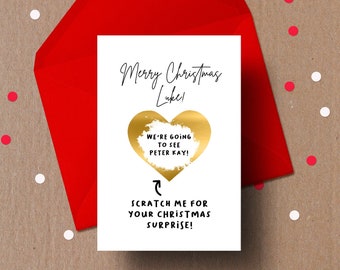 May include: A white card with a gold heart and the text "Merry Christmas Luke! We're going to see Peter Kay! Scratch me for your Christmas surprise!" printed on it.