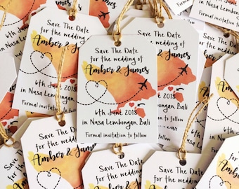 May include: Save the date cards with a watercolour map of an island with aeroplanes and a heart. The text reads "Save the Date for the wedding of Amber & James 6th June 2018 in Nusa Lembongan, Bali. Formal invitation to follow."
