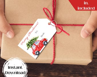 Puede incluir: Una etiqueta de regalo blanca con un coche rojo que lleva un árbol de Navidad. La etiqueta dice "¡Feliz Navidad!" con espacios para "Para" y "De". La etiqueta está atada a una caja de regalo marrón con una cuerda roja. El texto "3x2.5 in. y 4x2.75 in. incluidos" es visible en la esquina superior derecha de la imagen.