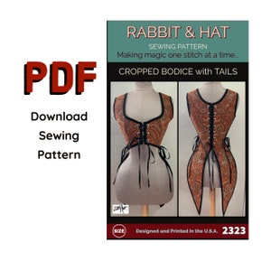 Peut inclure: Patron de couture PDF pour un corsage court avec des queues, intitulé "Rabbit & Hat Sewing Pattern: Making magic one stitch at a time... Cropped Bodice with Tails". Le patron est en tissu brun et orange à motif paisley avec des finitions noires. Le patron est conçu et imprimé aux États-Unis et comporte une étiquette de taille.