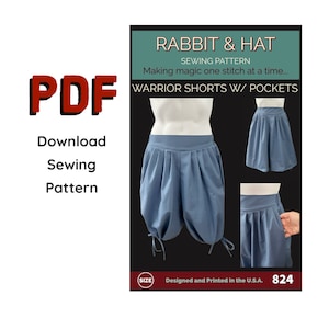 Puede incluir: Un patrón de costura PDF para "Warrior Shorts w/ Pockets" de Rabbit & Hat. El patrón presenta un pantalón corto azul con bolsillos y detalles de lazos. El texto "Making magic one stitch at a time..." también es visible.