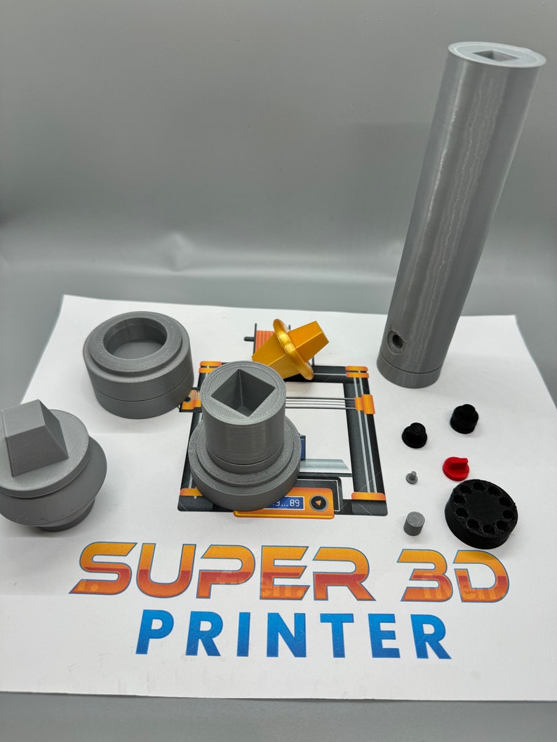 May include: A set of 3D printed parts for a 3D printer. The parts are grey and include a square base, a round base, a tall cylinder, and a small square piece. The parts are arranged on a white surface with the words "SUPER 3D PRINTER" printed on the surface.