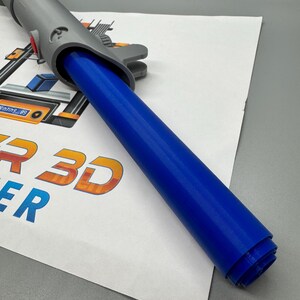 May include: A gray 3D printed lightsaber hilt with a blue lightsaber blade rolled up inside. The hilt has a yellow button and a red button. The blade is made of a flexible material.