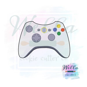 May include: White plastic video game controller cookie cutter with black outline and colored buttons. The buttons are yellow, blue, green, and red.