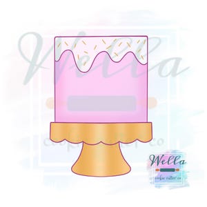 Puede incluir: Un pastel rosa y blanco con chispas doradas en la parte superior, sentado en un soporte para pastel dorado. El soporte para pastel tiene un borde festoneado.