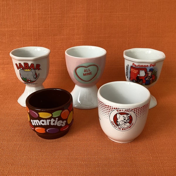 Assorted retro egg cups (sold separately): Babar the Elephant, Swizzels Love Hearts, Postman Pat, Tom and Jerry, Smarties, vintage egg cups