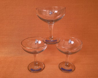 Un trio de lunettes coupe Babycham vintage des années 1950 avec un fauve blanc, des lettres bleues, une dorure dorée, une tige hexagonale, des lunettes Babycham vintage