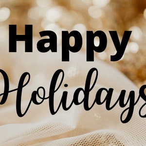 May include: Happy Holidays text in black lettering on a white fabric background with gold glitter out of focus.