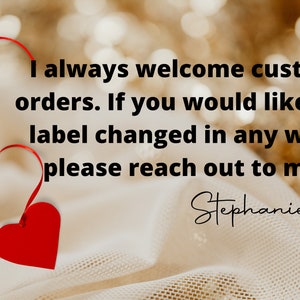 May include: A red heart with a red ribbon attached to it. The text reads: "I always welcome custom orders. If you would like the label changed in any way, please reach out to me. Stephanie"