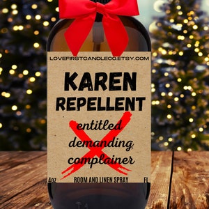 May include: A brown glass bottle with a red bow and a label that reads "Karen Repellent" with a red X over the words "entitled, demanding, complainer". The label also says "Room and Linen Spray" and "Lovefirstcandleco.etsy.com".