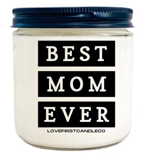 May include: A white candle jar with a black lid. The jar has a black label with the text "BEST MOM EVER" in white letters. The label also includes the text "LOVEFIRSTCANDLECO" in smaller white letters.