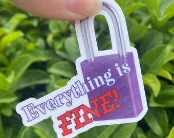 May include: A sticker in the shape of a purple padlock with the words "Everything is FINE!" in white and red. The sticker is held against a background of green leaves.
