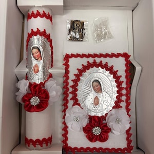 May include: A white and red religious set with a candle, a prayer book, and a rosary. The candle has a picture of the Virgin Mary on it. The prayer book has a picture of the Virgin Mary on the front. The rosary is in a clear plastic bag.