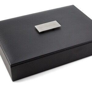May include: A black rectangular box with a textured surface and a silver metal handle.