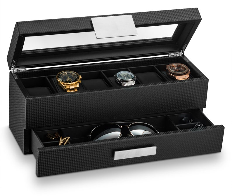 May include: A black watch box with a glass top and a drawer. The box has a carbon fibre pattern and holds six watches. The drawer has a silver handle and holds sunglasses and other accessories.