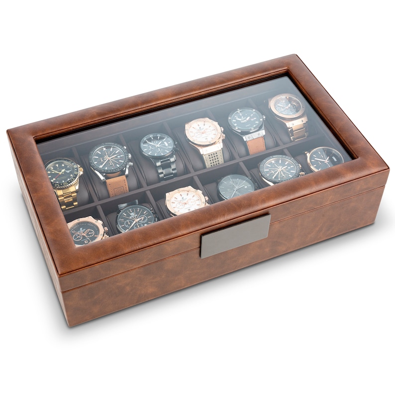 May include: A brown leather watch box with a glass top. The box has 12 compartments for storing watches. The box has a metal latch.