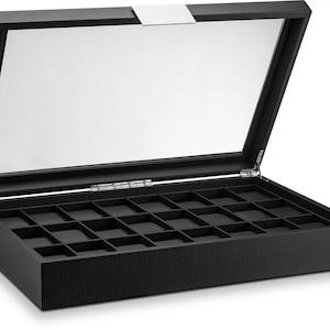 May include: Black watch display case with a clear glass top and a grid of individual compartments. The case is open, revealing the interior. The exterior has a textured pattern. The hinged lid has a silver accent.