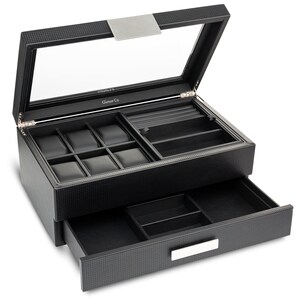 May include: Black watch and jewelry box with a clear glass top and a pull-out drawer. The box has multiple compartments for watches and jewelry. The interior is lined with black fabric. The box has a textured exterior and a silver-colored handle.