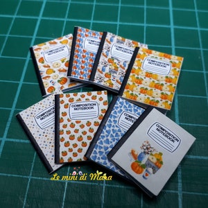 Può includere: Una collezione di quaderni di composizione in miniatura con vari disegni a tema autunnale. Le copertine presentano zucche, zucche e altri elementi autunnali. I quaderni sono tutti bianchi con testo nero che recita "Composition Notebook".