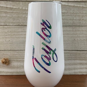 May include: White stainless steel tumbler with a colorful, patterned design that says "Taylor" on the side.